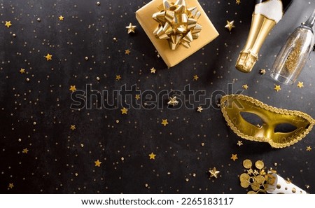 Happy Purim carnival decoration concept made from golden mask, wine, gift box and sparkle star on dark background. (Happy Purim in Hebrew, jewish holiday celebrate)