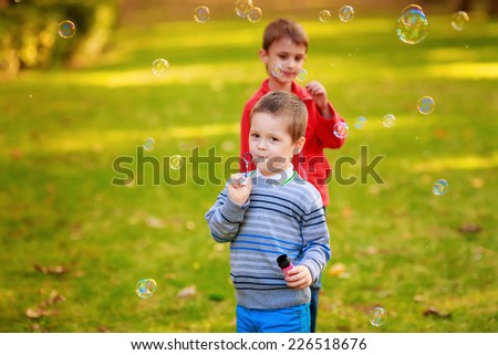 Happy kids with soap bubbles in the park.  