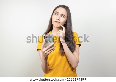 Asian woman reading news in mobile app and wondering fake news. Royalty-Free Stock Photo #2265194399