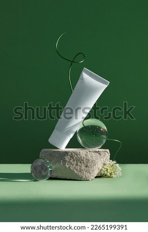 Front view of cosmetic jar decorated with rock and white flower in green background