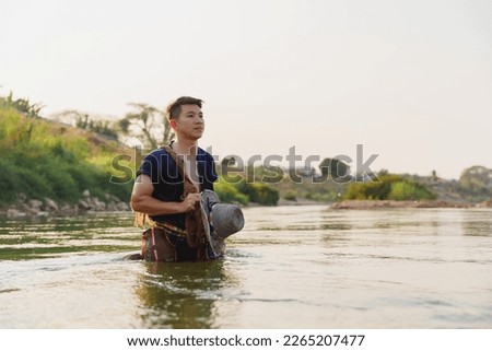 Asian fishermen are fishing with fishing nets by the river. Fresh water fish. Fishermans way of life. Royalty-Free Stock Photo #2265207477