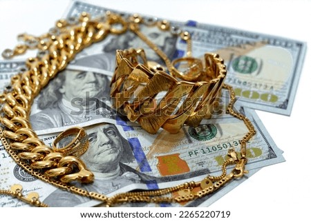 Jewellery or jewelry with USD American dollars cash money banknotes, brooches, rings, necklaces, earrings, pendants, bracelets, chain and cufflinks, Gold price in US dollar concept, selective focus
