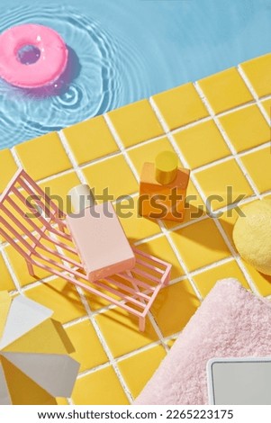 Summer vacation background concept with mini swimming float, beach chair and empty bottle of cosmetic. Mockup for design, advertising photo, top view.