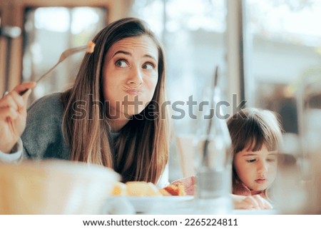 
Funny Mom Inspecting the Food in a Restaurant for its Freshness. Mother worried about allergies and nutritional restrictions 
 Royalty-Free Stock Photo #2265224811