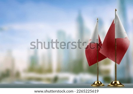 Small flags of the Bahrain on an abstract blurry background.