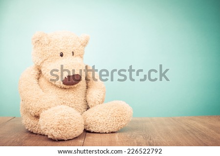 Teddy Bear toy sitting alone front mint green background