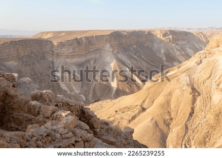 View during sunrise from the ruins of the fortress wall of the fortress of Masada to the adjoining gorge, in southern Israel