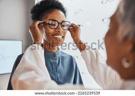 Glasses check, black woman and customer with store worker and optician looking at lense. Eye consulting, smile and eyewear assessment in a frame shop for vision test and prescription exam for eyes Royalty-Free Stock Photo #2265239539