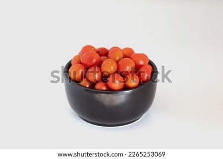 Cherry Tomato. Fresh red cherry tomatoes  in black bowl isolated on white background.