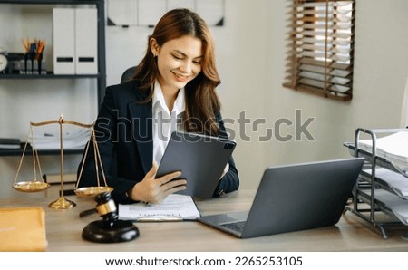 justice and law concept. asian woman lawyer working and judge in a courtroom the gavel, working with tablet and laptop and digital tablet computer on white table 
