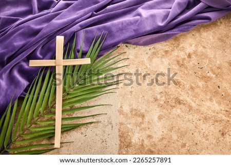 Lent season, Holy week and Good friday concept. Palm leave and cross on stone background Royalty-Free Stock Photo #2265257891
