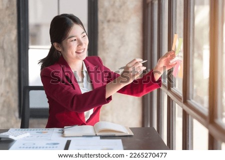 Hard working of asian people bookkeepers working with balance sheet and taxation, company quarterly reports of accounting and marketing. write on sticky notes.