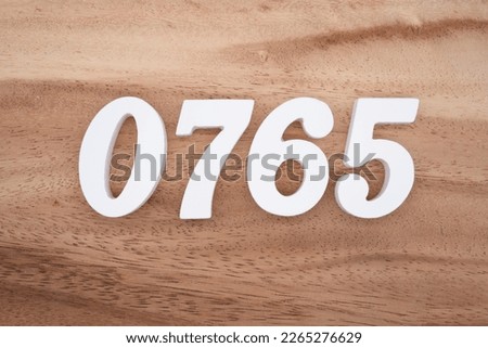 White number 0765 on a brown and light brown wooden background.