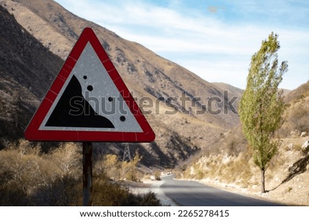Road sign "falling stones" Rockfall, Landslide in the mountains on the hill