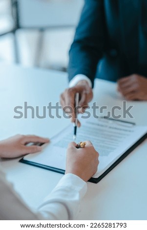 Suggestion to sign a contract, realtor suggestion a new house model assisting client to sign contract agreement with insurance to happy living building, concerning mortgage loan offer
