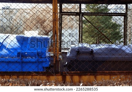 Garbage bin for waste segregation in a housing estate , blocks of apartment buildings in the background Royalty-Free Stock Photo #2265288535
