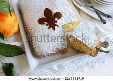 Schiacciata fiorentina, a carnival cake from Florence with orange flavor. Florentine lily on the cake sprinkled cocoa powder. Directly above. Royalty-Free Stock Photo #2265361919