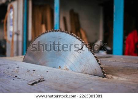 Close up of the saw blade of a circular saw in a wood workshop. Royalty-Free Stock Photo #2265381381