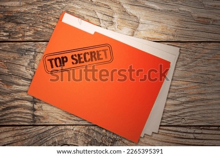 Orange file with documents and Top Secret stamp on wooden table, top view Royalty-Free Stock Photo #2265395391