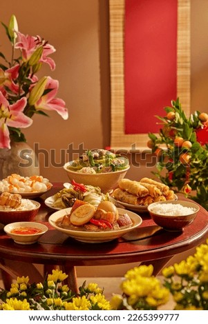 A wooden table full of Vietnamese traditional dishes commonly encountered on Tet holiday. Front view.Vietnamese Tet traditional food Royalty-Free Stock Photo #2265399777