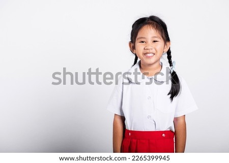 Asian adorable toddler smiling happy wearing student thai uniform red skirt standing in studio shot isolated on white background, Portrait little children girl preschool, Happy child Back to school Royalty-Free Stock Photo #2265399945