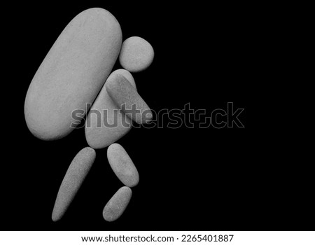 one Hiker man climbing with big heavy backpack on mountain. isolated on black background. male sign, symbol made from many white pebbles, stones. 
