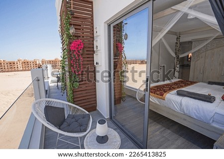 Terrace furniture of a luxury apartment in tropical resort with table and chairs on balcony by bedroom