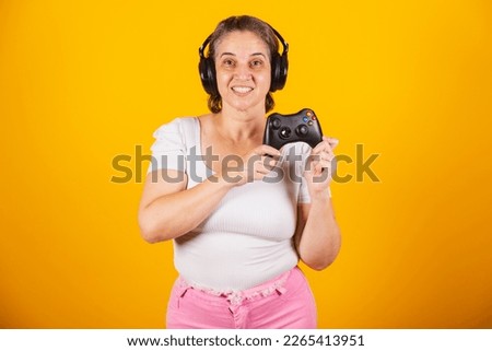 Adult Brazilian woman, mother, holding video game remote control, joystick. Gamer. using headphones, playing online.