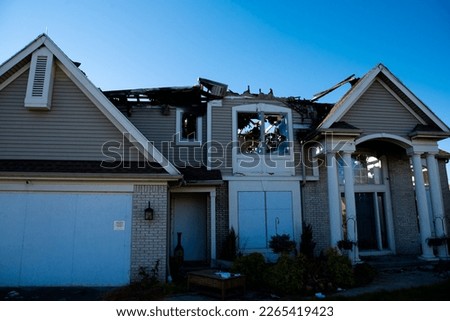 Front door garage of two-story single-family home with shingle roof ruined by fire in Rochester, New York, USA. Aftermath of destroyed residential home disaster for insurance claim concept Royalty-Free Stock Photo #2265419423