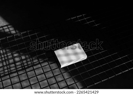 Business cards mockup template, industrial mood, with deep sunlit shadows. Isolated surface to place your design.  Royalty-Free Stock Photo #2265421429