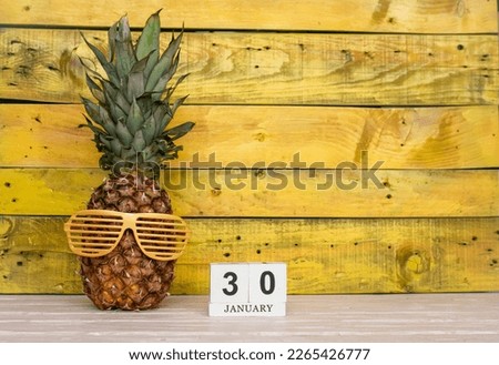 Creative planner calendar january with number  30. Pineapple character on bright yellow summer wooden background with calendar cubes.
