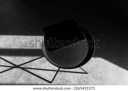 Tablet computer mockup template on a metal round table, concrete background with deep shadows, real photo. Blank isolated to place your design.	
