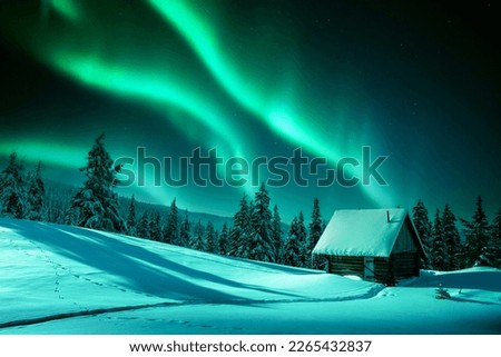 Fantastic winter landscape with wooden house in snowy mountains and northen light in night sky Royalty-Free Stock Photo #2265432837