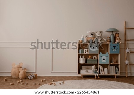 Interior design of kid room interior with copy space, wooden sideboard, round rug, beige wall with stucco, plush toys, ladder, wooden blockers and personal accessories. Home decor. Template. 