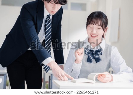 A high school girl asking a question to her teacher in the classroom Royalty-Free Stock Photo #2265461271