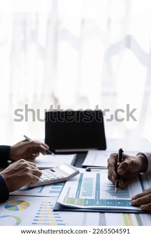 Businessmen meeting using laptop computers calculator stock market chart paper for analysis Quality improvement plan in business idea discussion meeting vertical image