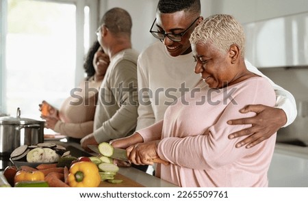 Happy African family preparing food recipe together in modern kitchen - Food and parents unity concept Royalty-Free Stock Photo #2265509761