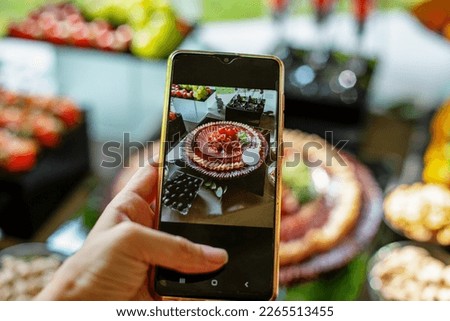 Food blogger takes photo on smartphone for social networks. Restaurant menu. Close up