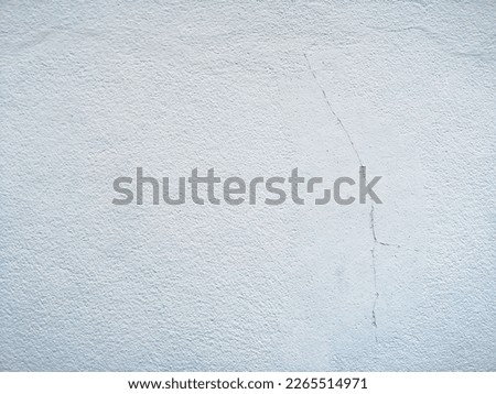 Background of white concrete wall.The scratched walls were smeared with cerulean oil.  Artistic background, abstract painting, hand drawn texture, crack on the wall of a damaged old building.