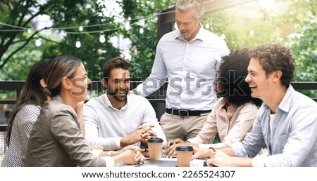 Merging their ideas around the table. Shot of a group of colleagues having a meeting at a cafe. Royalty-Free Stock Photo #2265524307