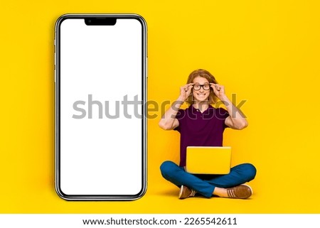 Full body photo of nice ginger guy sit hold laptop wear eyewear casual cloth isolated on yellow background