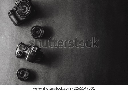 Professional cameras with different lenses on a black background.