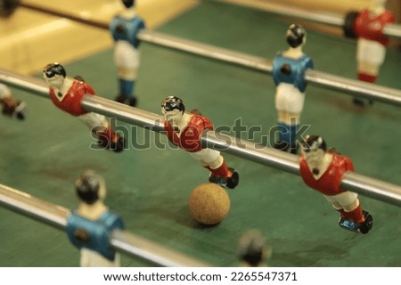 Table football, commonly called fuzboll or foosball (as in the German Fußball "football") and sometimes table soccer, is a table-top game that is loosely based on association football. Royalty-Free Stock Photo #2265547371