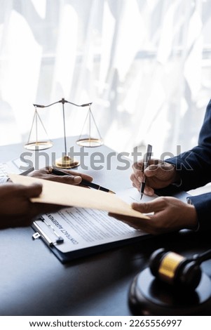 Businessman and male lawyer consulting with legal meeting team presenting signed contract with hammer and law to clients justice and lawyer business partner meeting concept vertical image
