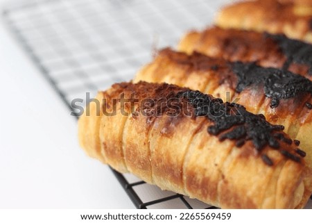 a close up of Chocolate Cheese Bolen. made of flour, cheese, chocolate, with banana filling. served on a cake rack. isolated white background.