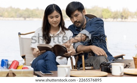 Couple camping for the weekend in the woods near the river, Leisure and relaxation activities in the midst of nature, Man taking photo of woman to capture memories, Couple outdoor leisure activities.
