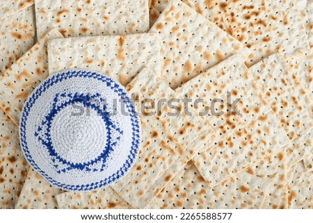 Passover celebration concept. White kippah with Star of David on Matzah texture background. Passover food. Pesach Jewish holiday. Traditional ritual Jewish bread. Passover food. Top view. Mock up. Royalty-Free Stock Photo #2265588577