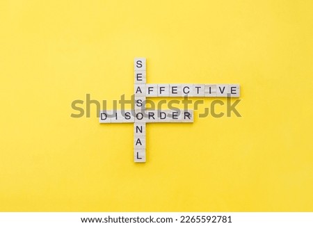Words Seasonal Affective Disorder on wooden blocks with letters on yellow background. Minimal SAD concept. Copy space Royalty-Free Stock Photo #2265592781