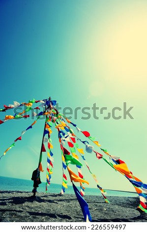 Buddhist Tibetan prayer flags waving in the wind against blue sky 