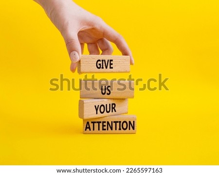 Attention symbol. Concept word Give us your attention on wooden blocks. Beautiful yellow background. Businessman hand. Business and Give us your attention concept. Copy space